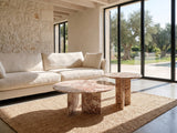 Marzamemi Rosa Marble Nesting Coffee Tables, Set of 2 on a jute rug in front of a linen sofa in a poolside villa