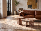 Marzamemi Rosa Marble Nesting Coffee Tables, Set of 2 on a vintage rug in front of a leather sofa in an industrial loft
