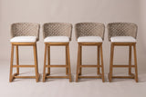 The four Mascali bar stools side by side from the front: wicker backs, pale cushions, acacia legs and the footrest rails