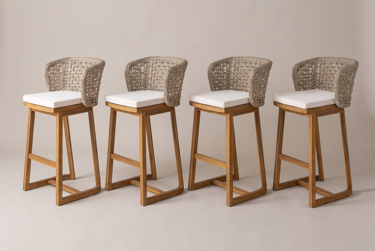 The four Mascali acacia bar stools with curved wicker backs and pale cushions, three-quarter view on a light studio backdrop