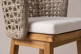 Close-up of the open-lattice wicker back of a Mascali stool where it meets the beige cushion and the acacia seat frame