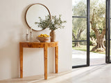 Massafra Burl Half-Moon Console Table under a round bronze mirror beside a glass wall onto an olive garden in a sunlit villa