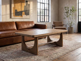 Matelica Reclaimed Pine Trestle Coffee Table on a vintage rug in front of a leather sofa in an industrial loft