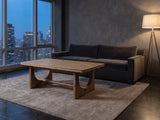 Matelica Reclaimed Pine Trestle Coffee Table on a wool rug in front of a velvet sofa in a city penthouse at blue hour