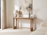 Matelica Reclaimed Pine Trestle Console Table against a plaster wall under an abstract canvas in a bright living room