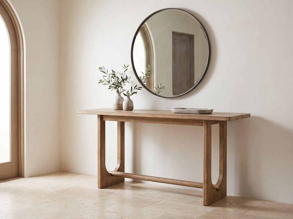 Matelica Reclaimed Pine Trestle Console Table under a round mirror in a travertine entryway