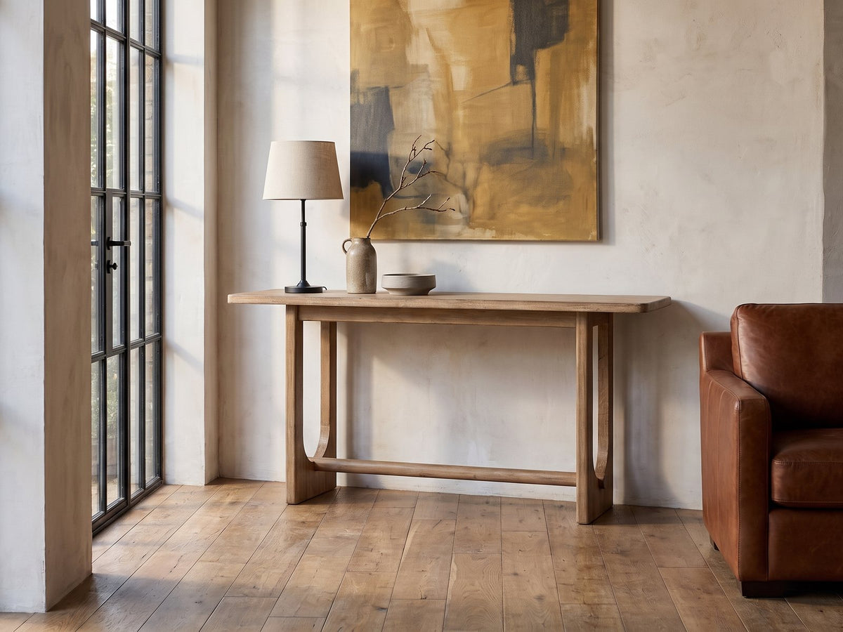 Matelica Reclaimed Pine Trestle Console Table against a plaster wall in an industrial loft