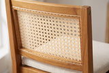 Close-up of the woven cane-pattern back of a Mazzarino stool in its acacia frame, with a round bolt head
