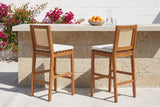 Two Mazzarino acacia bar stools at a coquina stone outdoor kitchen with a limestone top in a walled St. Augustine garden, bougainvillea on a white wall behind (outdoor kitchen not included)