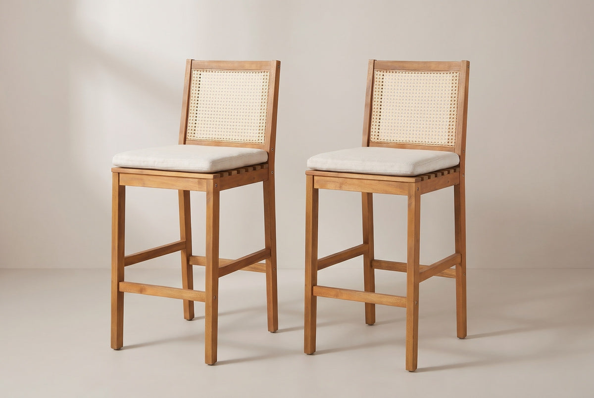 The two Mazzarino bar stools side by side, both turned the same way: cane backs, pale beige cushions, square legs and the low footrest rails