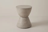 The Mazzaro light grey concrete hourglass side table, three-quarter view on a light studio backdrop