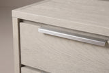 The upper drawer of the Melfi nightstand: one long brushed metal pull along the top edge with its lip folding down over the wire-brushed oak front
