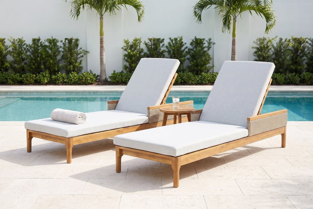 The Menfi set of two acacia chaise loungers on a coral-stone pool terrace in Naples, Florida, white garden walls and palms behind (side table and towel not included)