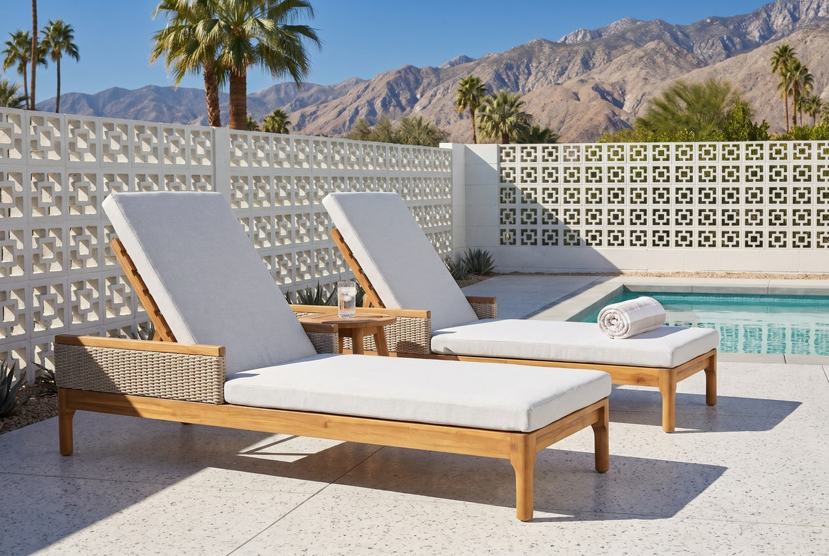 The Menfi set of two acacia chaise loungers on a terrazzo pool deck in Palm Springs, a white breeze-block wall and the mountains behind (side table and towel not included)