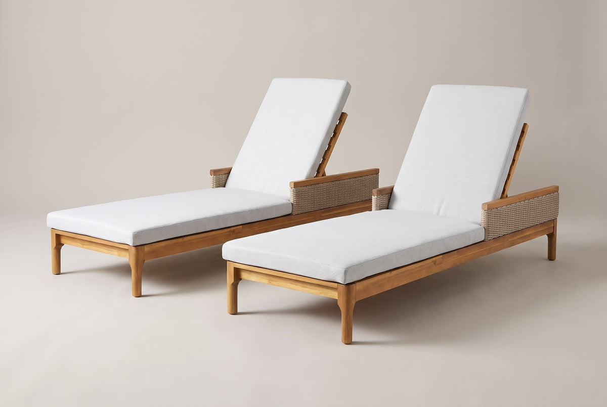 The Menfi set of two acacia chaise loungers with light grey cushions, three-quarter view from the foot end on a light studio backdrop