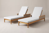 The Menfi set of two acacia chaise loungers with light grey cushions, three-quarter view from the foot end on a light studio backdrop