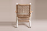 The Militello chair from behind: the open-grid wicker back, round white post caps, the white band joining the arms and the two rear runners