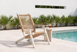 Militello lounge chair on pale shellstone pavers beside a pool at a modern Sarasota house, a white stucco wall and palmettos behind (side table not included)
