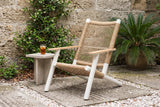 Militello lounge chair in a St. Augustine courtyard with a coquina stone wall, star jasmine and a potted sago palm (side table not included)