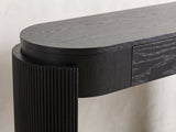 Close-up of the Minervino Black Oak Fluted Racetrack Console Table: the reeded curved leg wrapping the rounded end of the apron