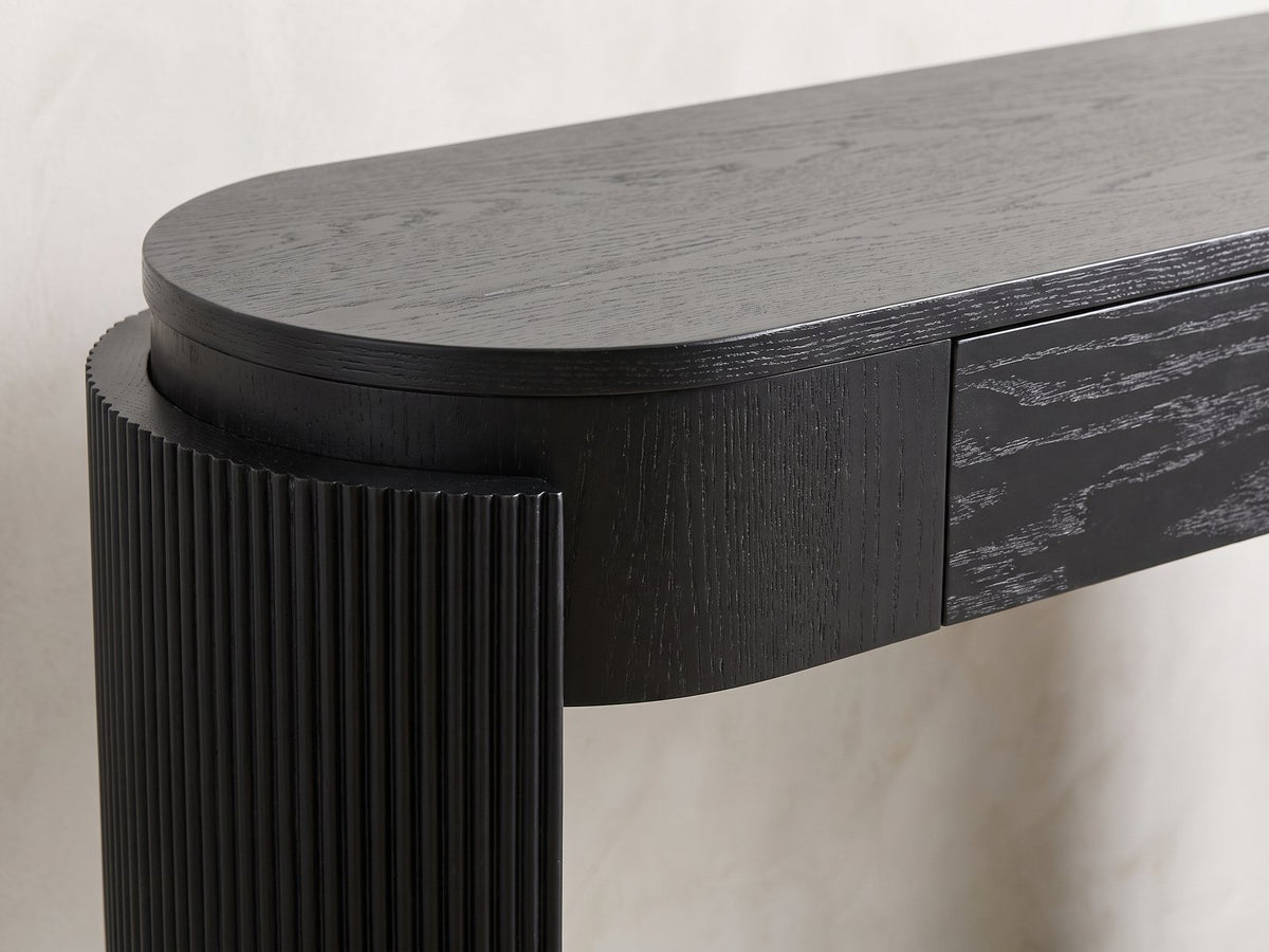 Close-up of the Minervino Black Oak Fluted Racetrack Console Table: the reeded curved leg wrapping the rounded end of the apron