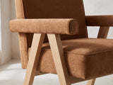 Close-up of the Minturno 95-Inch Light Oak Sled Base Dining Set with 6 Chairs: the padded arm bolster and inverted-V oak leg frame of an armchair in caramel chenille