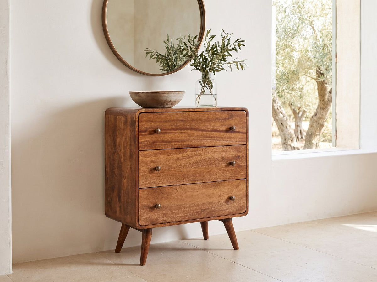 Mira 28-Inch Honey Caramel Solid Mango 3-Drawer Chest under a round bronze mirror in a villa bedroom