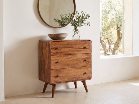 Mira 28-Inch Honey Caramel Solid Mango 3-Drawer Chest under a round bronze mirror in a villa bedroom