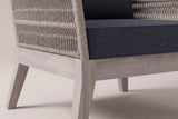 Close view of a Mistretta front corner: the greywash acacia base rail, a splayed square leg, the rope-wrapped arm and the slate grey seat cushion