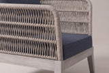 Close-up of the woven grey rope on a Mistretta arm: open zigzag rows, horizontal ribs and the rounded rope edge, above the greywash acacia base