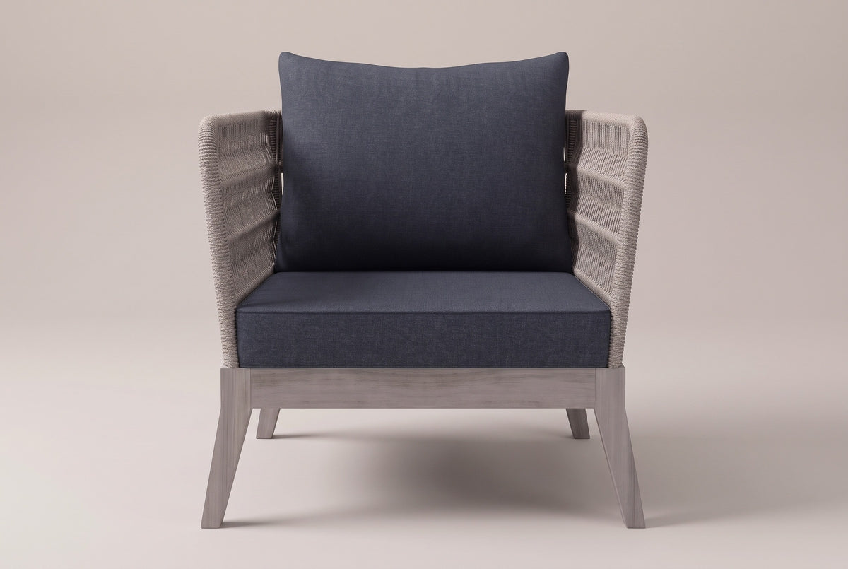 The Mistretta lounge chair seen straight from the front: flared rope arms, slate grey seat and back cushions, greywash acacia base