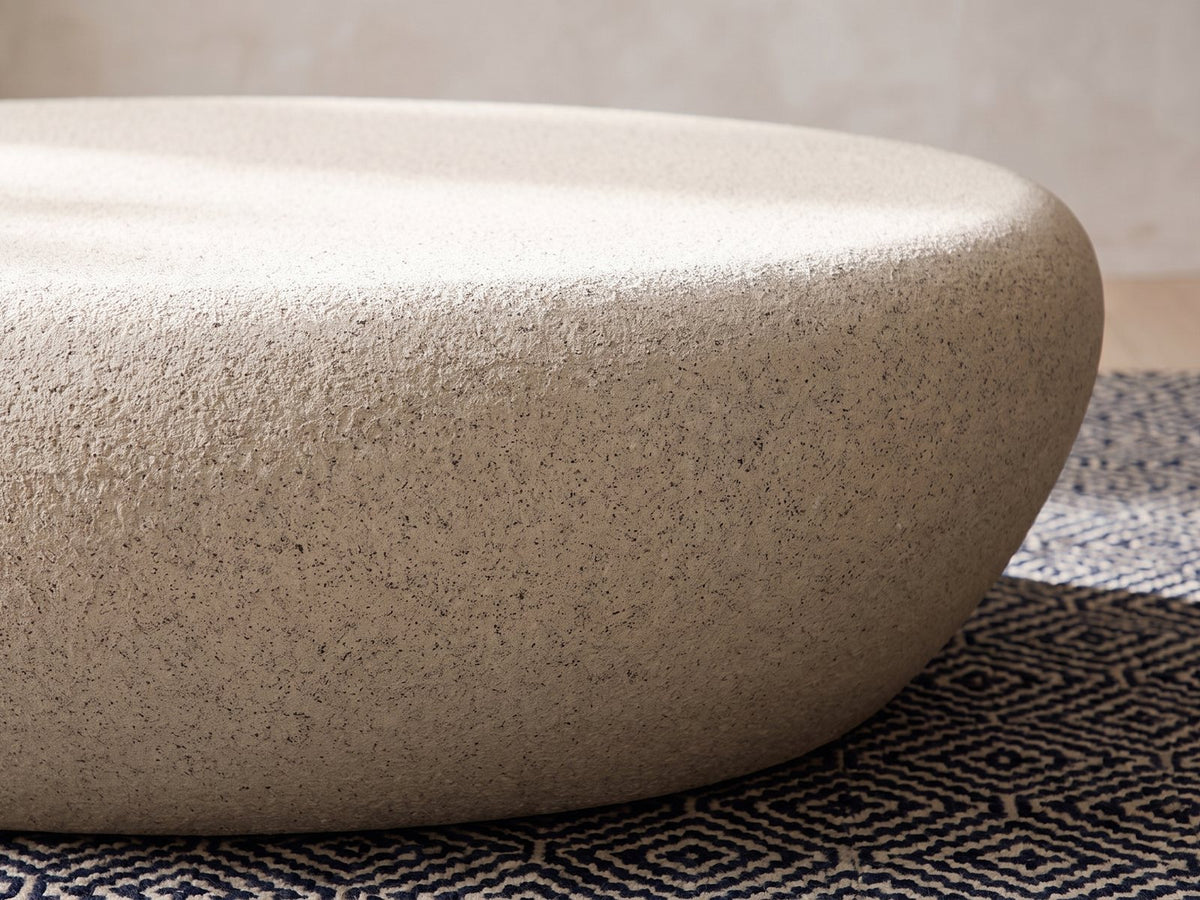 Close-up of the Modica Cream Fiberglass Pebble Coffee Table: the soft rolled edge where the top turns into the side