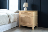 Mogoro pine and cane nightstand with a ceramic lamp beside a bed in a Seattle bedroom with a deep navy board-and-batten wall and grey oak floorboards