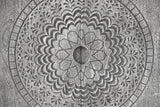 The centre of the Molfetta medallion: the round carved hollow between the two doors, the eight-point star, scalloped petals, leaf sprays and the outer ring of small blocks