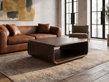 Molveno Walnut-Tone Wood Veneer Coffee Table on a vintage rug in front of a leather sofa in an industrial loft