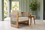 Mondello acacia club chair on a covered lanai in Naples, Florida with a pale travertine floor and a sage-green board-and-batten wall (side table and plant not included)