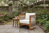 Mondello acacia club chair in a Savannah courtyard garden with an old mossy brick wall, a wrought-iron gate and flagstone paving (side table not included)