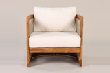 The Mondello club chair seen from the front: the ivory seat and back cushions, the acacia seat rail and the open arch under the seat