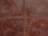 Close-up of the Moneglia Distressed Brown Top-Grain Buffalo Leather Round Pouf: the four-panel round top, its two topstitched seams crossing at the centre