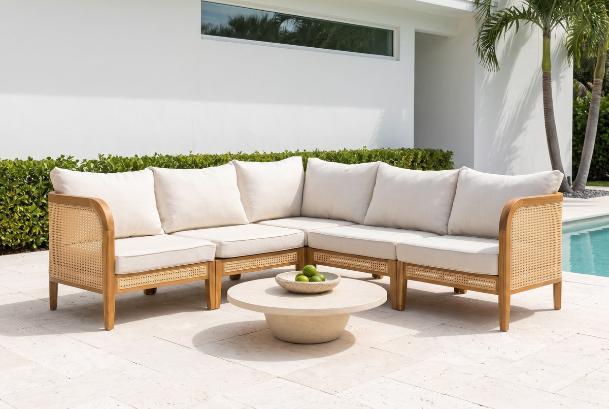 Monreale acacia and cane corner sectional on a travertine pool terrace at a Sarasota, Florida house, a white stucco wall, royal palms and a clipped hedge (coffee table not included)