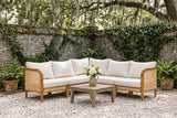 Monreale acacia and cane corner sectional on oyster-shell gravel in a Savannah, Georgia courtyard, an old grey brick wall with ivy and a live oak behind (coffee table not included)