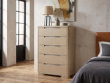 Monselice 38-Inch Light Elm 5-Drawer Chest against a plaster wall in an industrial loft bedroom
