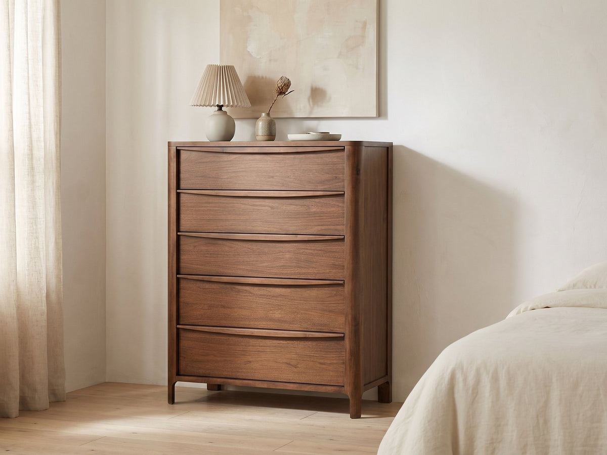 Montagnana 40-Inch Walnut 5-Drawer Chest against a plaster wall under an abstract canvas in a bright bedroom