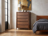 Montagnana 40-Inch Walnut 5-Drawer Chest against a plaster wall in an industrial loft bedroom