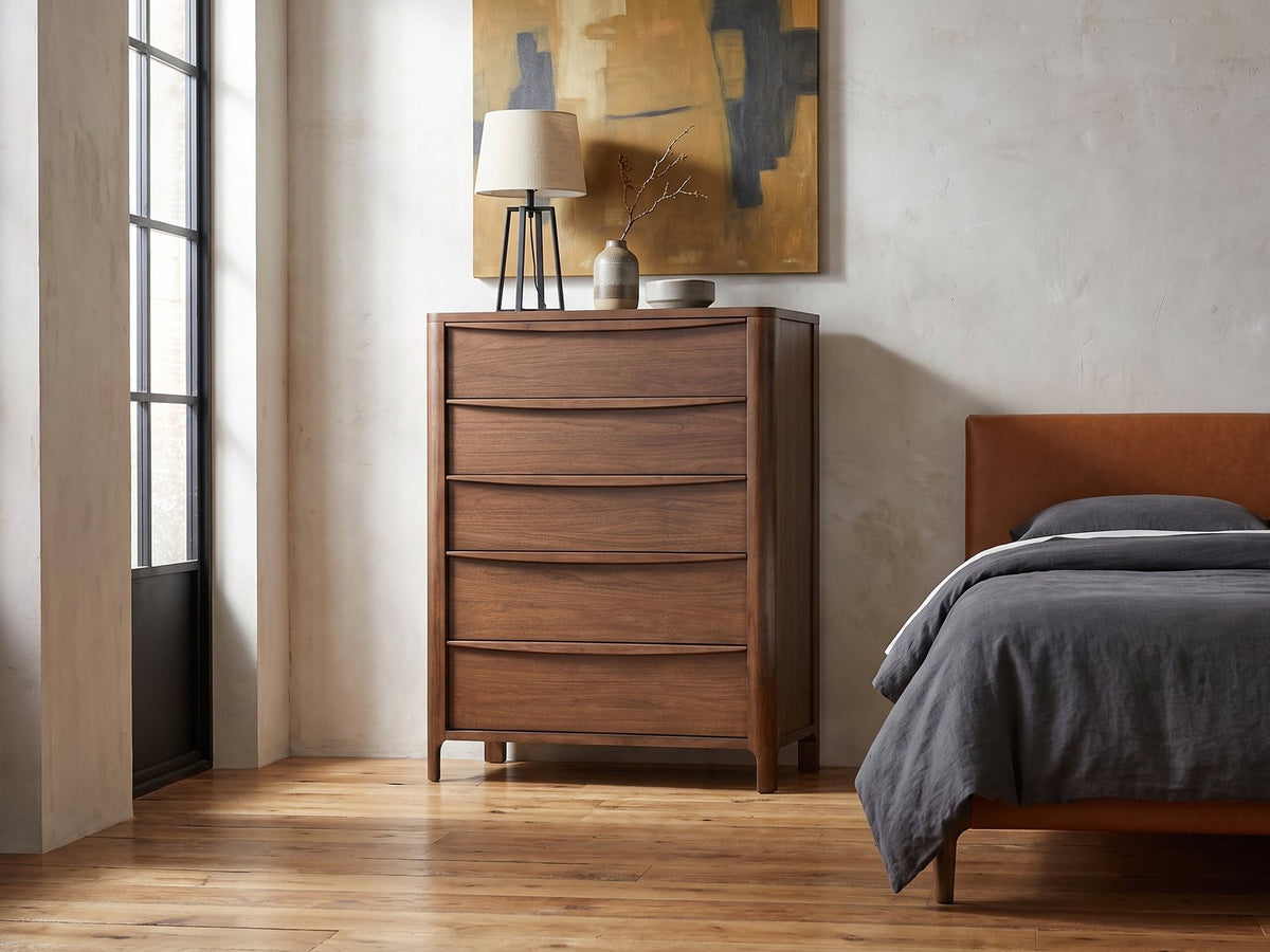 Montagnana 40-Inch Walnut 5-Drawer Chest against a plaster wall in an industrial loft bedroom