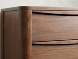 Close-up of the Montagnana 40-Inch Walnut 5-Drawer Chest: the carved arched finger pulls along the tops of the walnut drawers