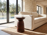 Montalbano Carved Mango Pedestal Side Table beside a linen sofa in a poolside villa