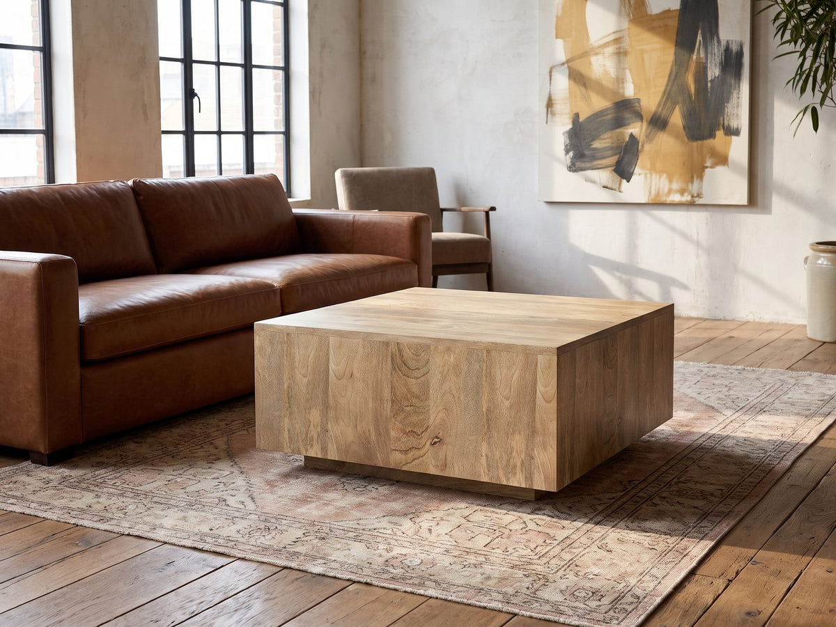 Montecatini Square Mango Coffee Table on a vintage rug in front of a leather sofa in an industrial loft