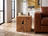 Montefiore Teak Root Cube Side Table beside a cognac leather armchair in an industrial loft