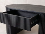 Close-up of the Monterosso Black Wood Veneer Fluted Oval Coffee Table: the slatted drawer pulled out of the fluted apron